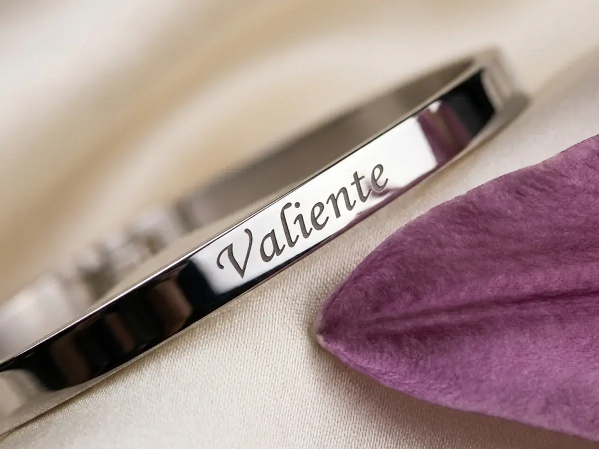 Pulsera LIRIO grabada con la palabra Valiente junto a un pétalo lila